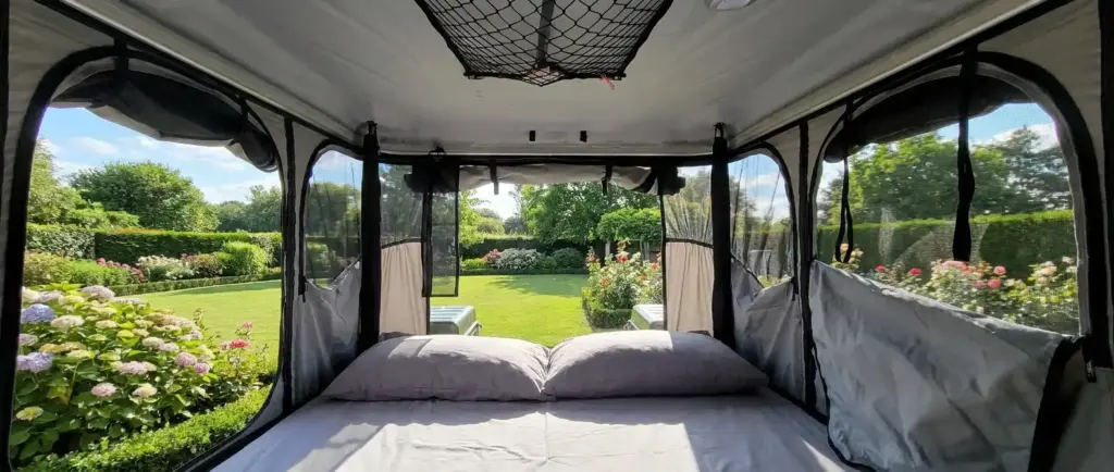 Vue panoramique depuis l'intérieur d'une tente James Baroud Evasion fenêtres ouvertes sur jardin